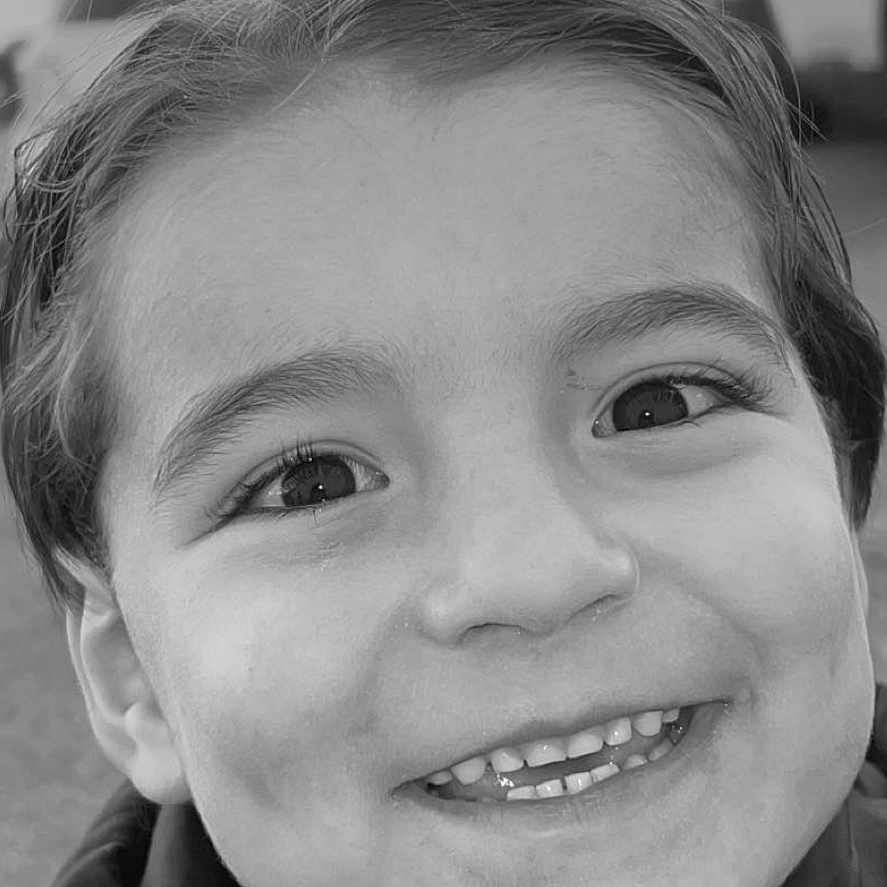 Chakir a rejoint le concours — aidez-le/la à gagner de superbes lots ! background, black_and_white, building, car, child, closeup, daylight, expression, eyes, face, happy, head, jacket, outdoor, person, portrait, smiling, teeth, wet_hair, young