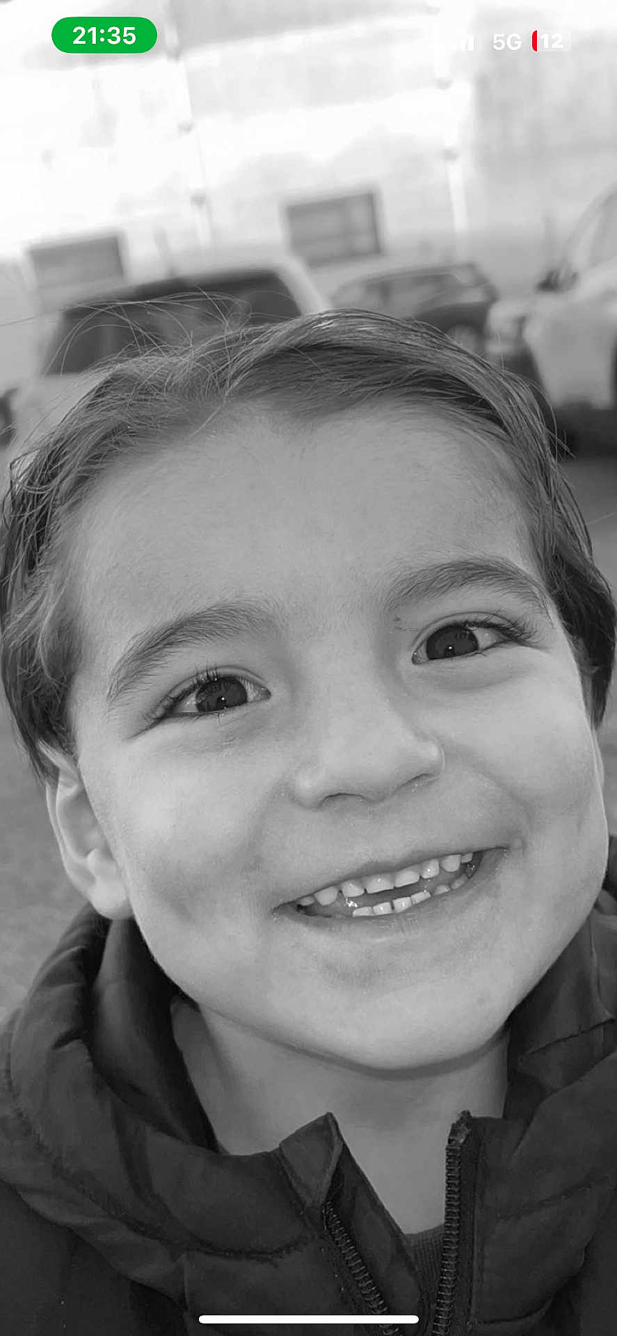 Chakir a rejoint le concours — aidez-le/la à gagner de superbes lots ! child, smiling, face, portrait, black_and_white, jacket, wet_hair, happy, outdoor, closeup, eyes, teeth, person, head, expression, young, background, car, building, daylight