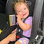 baby, car_interior, car_seat, child, child_safety, cute, daisies, fingers, hair, happy, infant, legs, playful, purple_clothing, safety_harness, seatbelt, sitting, smiling, toy, vehicle