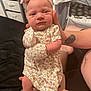 Aria joined the competition — help win amazing prizes! baby, infant, floral_dress, mittens, headband, tattoo, hand, person, indoor, bedroom, furniture, drawer, blanket, soft_lighting, close_up, cute, newborn, skin, expression, holding