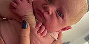 Aria is registered to the contest to win money with this photo: baby, newborn, infant, hand, holding, skin, face, eyes, person, indoors, blanket, nail_polish, tattoo, curious, expression, closeup, fingers, arm, home, soft_lighting