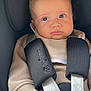 Noah participe au concours pour gagner de l'argent avec cette photo : baby, infant, child, car_seat, safety_harness, clothing, beige, face, hand, eyes, expression, cute, indoors, seat, straps, portrait, young, person, head, skin
