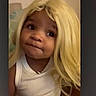 Naomi is registered to the contest to win money with this photo: child, toddler, portrait, blonde_wig, wig, funny, indoor, face, eyes, smiling, white_shirt, sleeveless, seated, arched_frame, dark_background, close_up, playful, costume, expression, photography