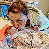 baby, newborn, hospital, medical_equipment, woman, kiss, tattoos, face, infant, patient, love, care, healthcare, diaper, bed, tubes, wires, monitoring, person, indoor