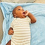 Kaylon participe au concours pour gagner de l'argent avec cette photo : baby, infant, child, blanket, blue_blanket, onesie, striped_clothing, hand, thumb, face, looking_up, lying_down, skin, cute, indoors, soft_texture, couch, comfort, young_child, expression