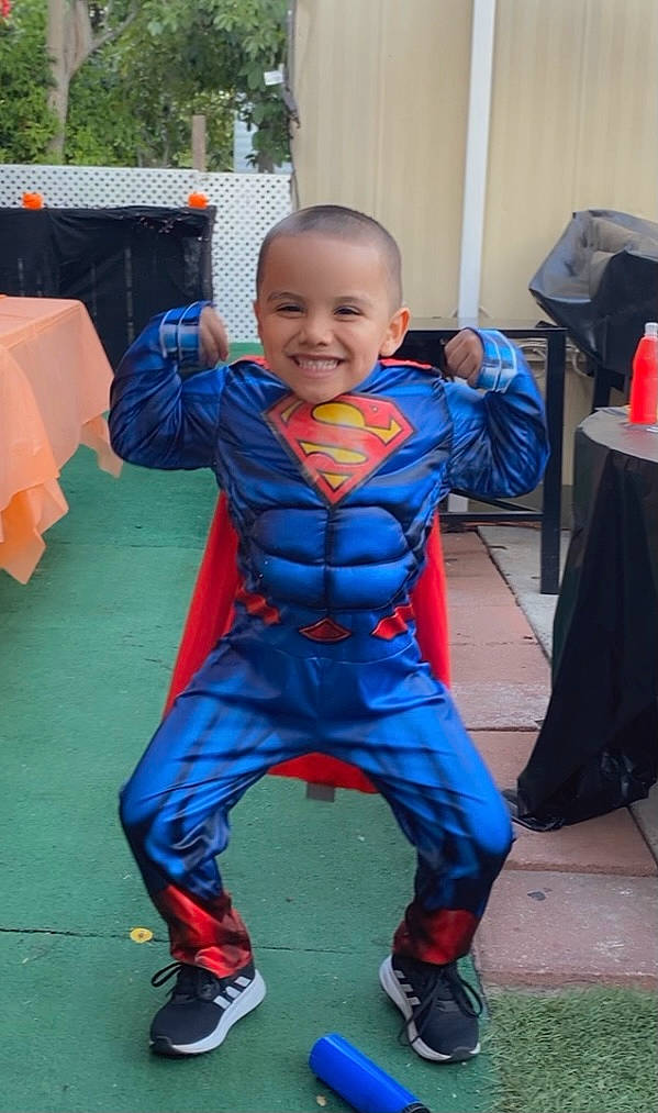 Eddie is registered to the contest to win money with this photo: baby, baby_toddler_clothing, chair, child, costume, electric_blue, event, fictional_character, fun, hairstyle, happy, joy, leisure, person, personal_protective_equipment, play, recreation, sitting, smile, sneakers