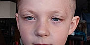Colten is registered to the contest to win money with this photo: child, boy, portrait, face, blue_eyes, blonde_hair, short_hair, indoor, casual_clothing, red_shirt, black_shirt, young, person, serious_expression, head_and_shoulders, closeup, human, skin, eyebrows, lips
