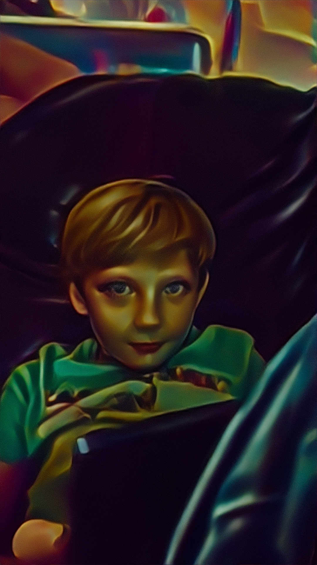 Colten is registered to the contest to win money with this photo: child, boy, blanket, indoor, device, tablet, seated, face, portrait, light, hair, clothing, relaxing, dark_background, couch, home, young, technology, casual, resting