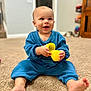 Evelina joined the competition — help win amazing prizes! baby, child, blue_clothing, carpet, indoor, toy, yellow, smiling, happy, sitting, person, face, hand, foot, home, room, blurred_background, cute, infant, play