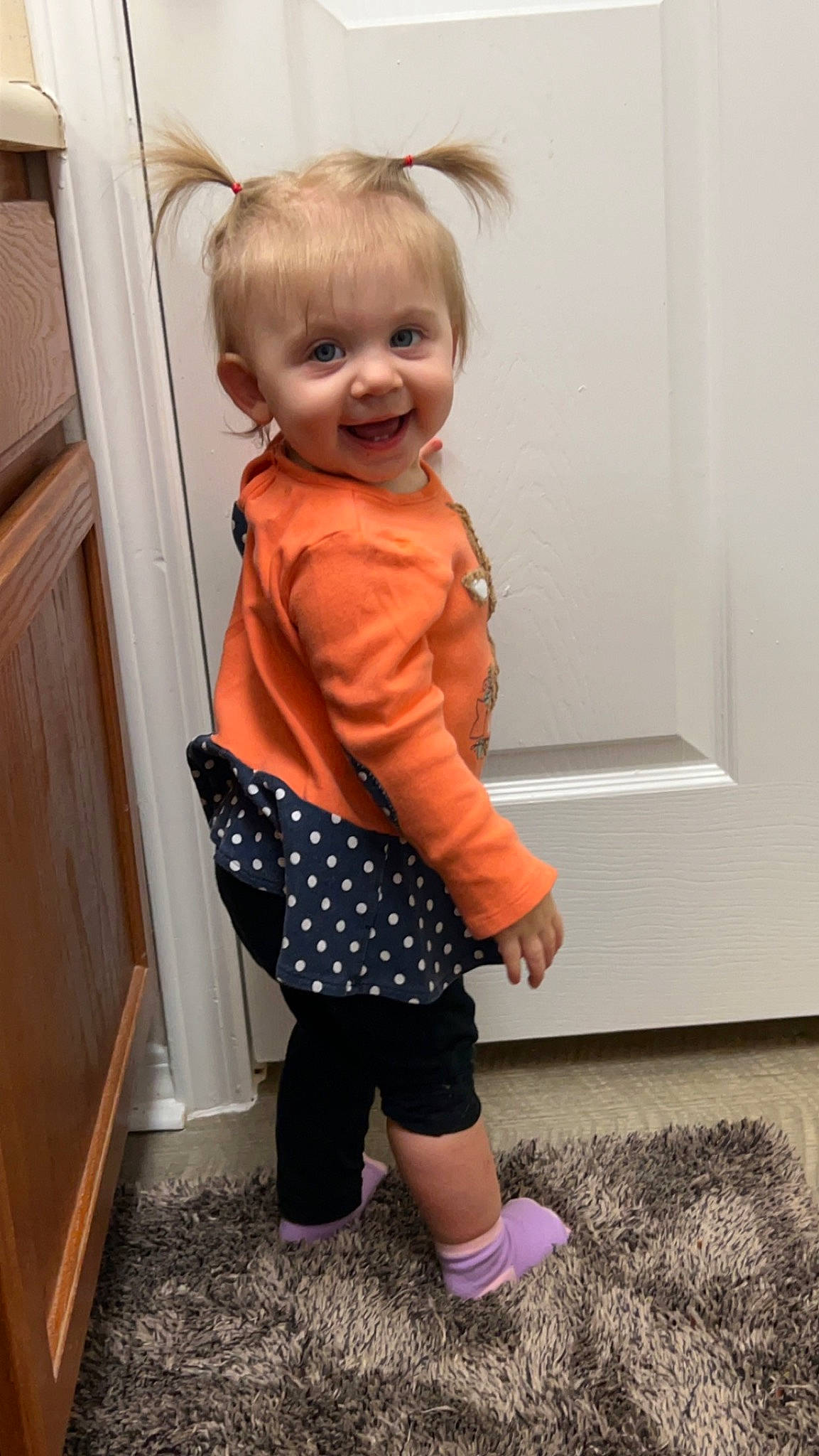 Stella joined the competition — help win amazing prizes! baby, baby_toddler_clothing, cabinetry, child, costume, door, flooring, hardwood, human_leg, joy, knee, pattern, person, plaid, room, shoulder, sleeve, smile, standing, textile