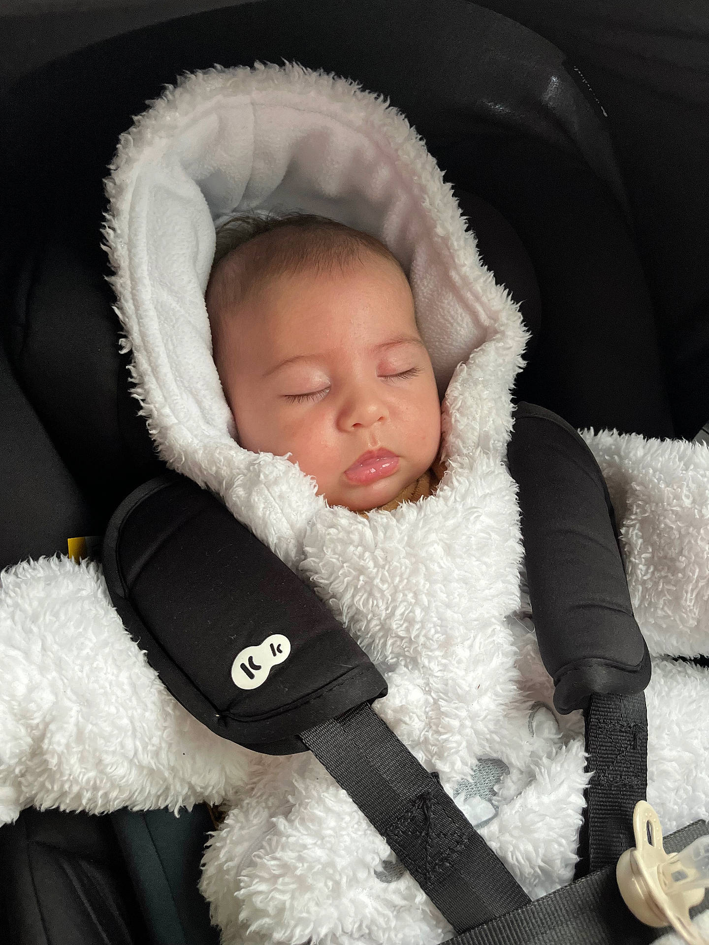 Amélya a rejoint le concours — aidez-le/la à gagner de superbes lots ! baby, black_background, car_seat, child, closed_eyes, cozy, cute, face, fluffy, harness, head, indoors, infant, peaceful, portrait, seat_belt, sleeping, warm_clothing, white_clothing, young_child