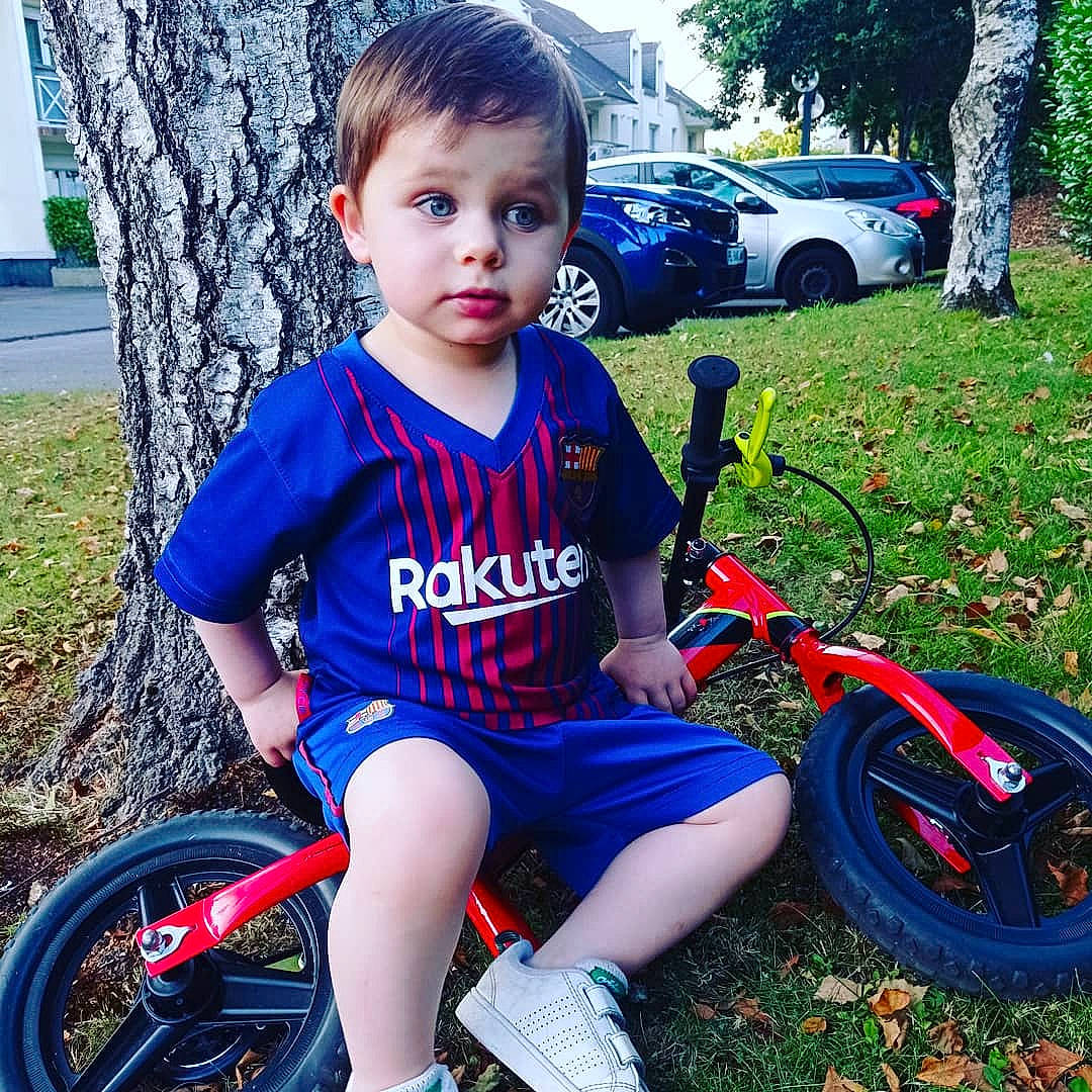 Lorenzo participe au concours pour gagner de l'argent avec cette photo : automotive_tire, bicycle, bicycle_accessory, bicycle_frame, bicycle_handlebar, bicycle_saddle, bicycle_tire, bicycle_wheel, blue, grass, happy, land_vehicle, motor_vehicle, person, plant, shoe, shorts, tire, toddler, vehicle