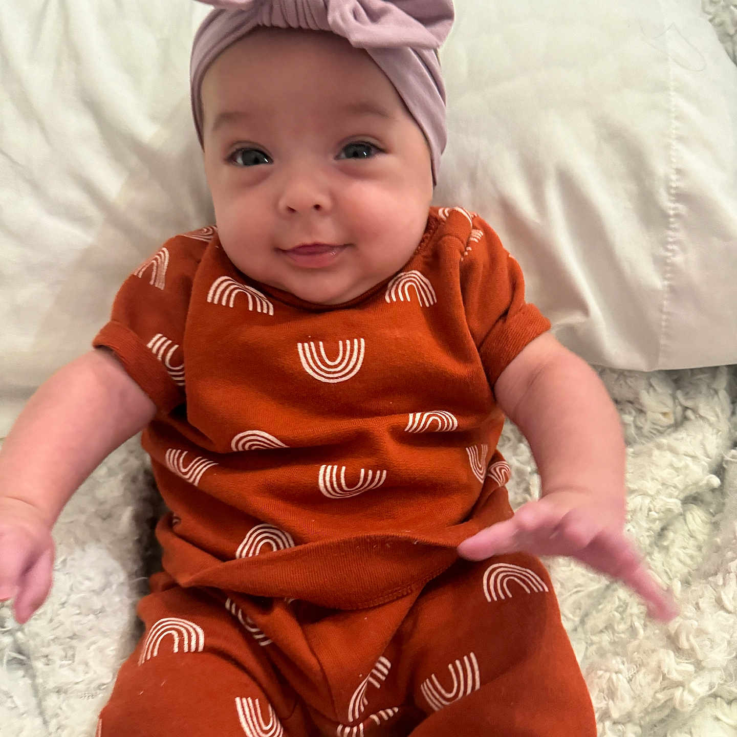 Mila is registered to the contest to win money with this photo: accessories, applique, baby, beanie, bed, blanket, bodypart, bonnet, cap, clothing, costume, couch, cushion, dress, face, finger, fleece, furniture, hand, happy