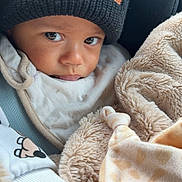 Ayden a rejoint le concours — aidez-le/la à gagner de superbes lots ! baby, child, toddler, beanie, hat, blanket, car_seat, bib, closeup, portrait, eyes, gaze, hand, cozy, soft_texture, fleece, warmth, mischievous_expression, infant_clothing, car_trip