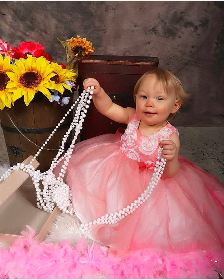 Sabriana is registered to the contest to win money with this photo: bridal_accessory, bridal_party_dress, dress, facial_expression, fashion, fashion_design, flash_photography, flower, gown, happy, headgear, headpiece, magenta, person, petal, pink, product, smile, textile, toddler