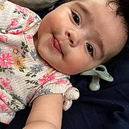 Amarilla joined the competition — help win amazing prizes! baby, child, face, tongue, floral_clothing, pacifier, pillow, arm, skin, cute, infant, lying_down, rosy_cheeks, expression, indoors, smiling, person, closeup, portrait, happy