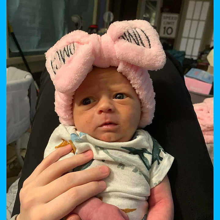 Dayton Mathew joined the competition — help win amazing prizes! baby, infant, hand, pink_headband, bunny_ears, clothing, indoor, person, newborn, cute, portrait, expression, human, holding, soft, accessory, child, face, small, toddler
