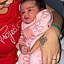 baby, infant, person, adult, hand, tattoo, clothing, pink_outfit, red_shirt, holding, closeup, face, portrait, newborn, cute, indoor, family, love, skin, baby_clothes