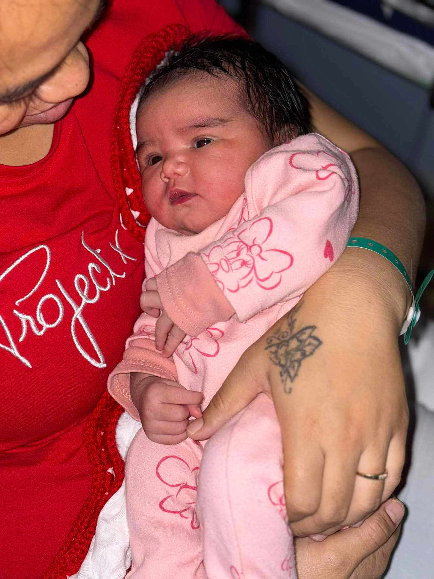 Naheana a rejoint le concours — aidez-le/la à gagner de superbes lots ! baby, infant, person, adult, hand, tattoo, clothing, pink_outfit, red_shirt, holding, closeup, face, portrait, newborn, cute, indoor, family, love, skin, baby_clothes