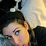 woman, cat, black_and_white_cat, headband, braid, pillow, bed, indoor, face, funny_face, pet, animal, cute, resting, closeup, casual, portrait, relaxed, home, feline