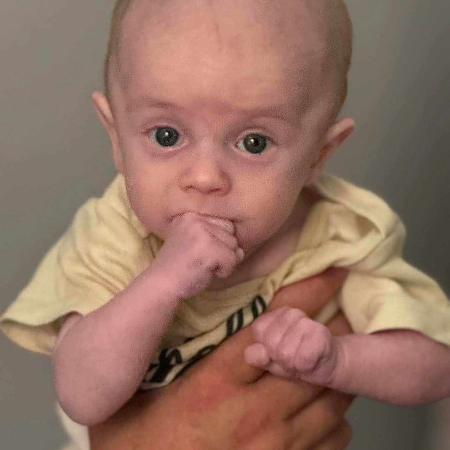 Kadence is registered to the contest to win money with this photo: accessories, arm, baby, biting, bodypart, bracelet, clothing, face, finger, hand, happy, head, newborn, person, photography, portrait, sitting, skin, smile, t_shirt