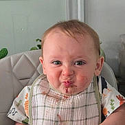 Oliver is registered to the contest to win money with this photo: baby, bib, food, messy_face, high_chair, expression, indoor, child, clothing, face, person, cute, infant, smile, funny_face, table, green_plant, background, skin, hair