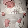 baby, sleeping, headband, bow, white_sweater, embroidery, name, arabella, cushioned_seat, infant, sock, soft_fabric, hands, legs, pink, comfortable, child, resting, cute, indoors