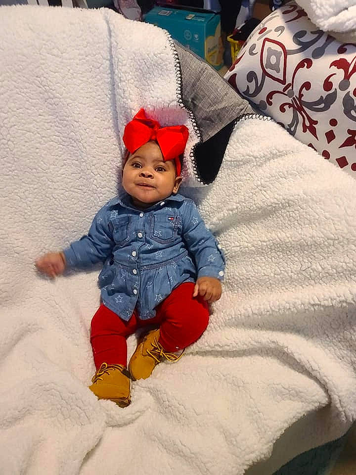 Blu is registered to the contest to win money with this photo: baby, baby_toddler_clothing, child, comfort, couch, fictional_character, flooring, fun, happy, headwear, leisure, linens, pattern, person, play, product, sitting, sleeve, textile, toddler