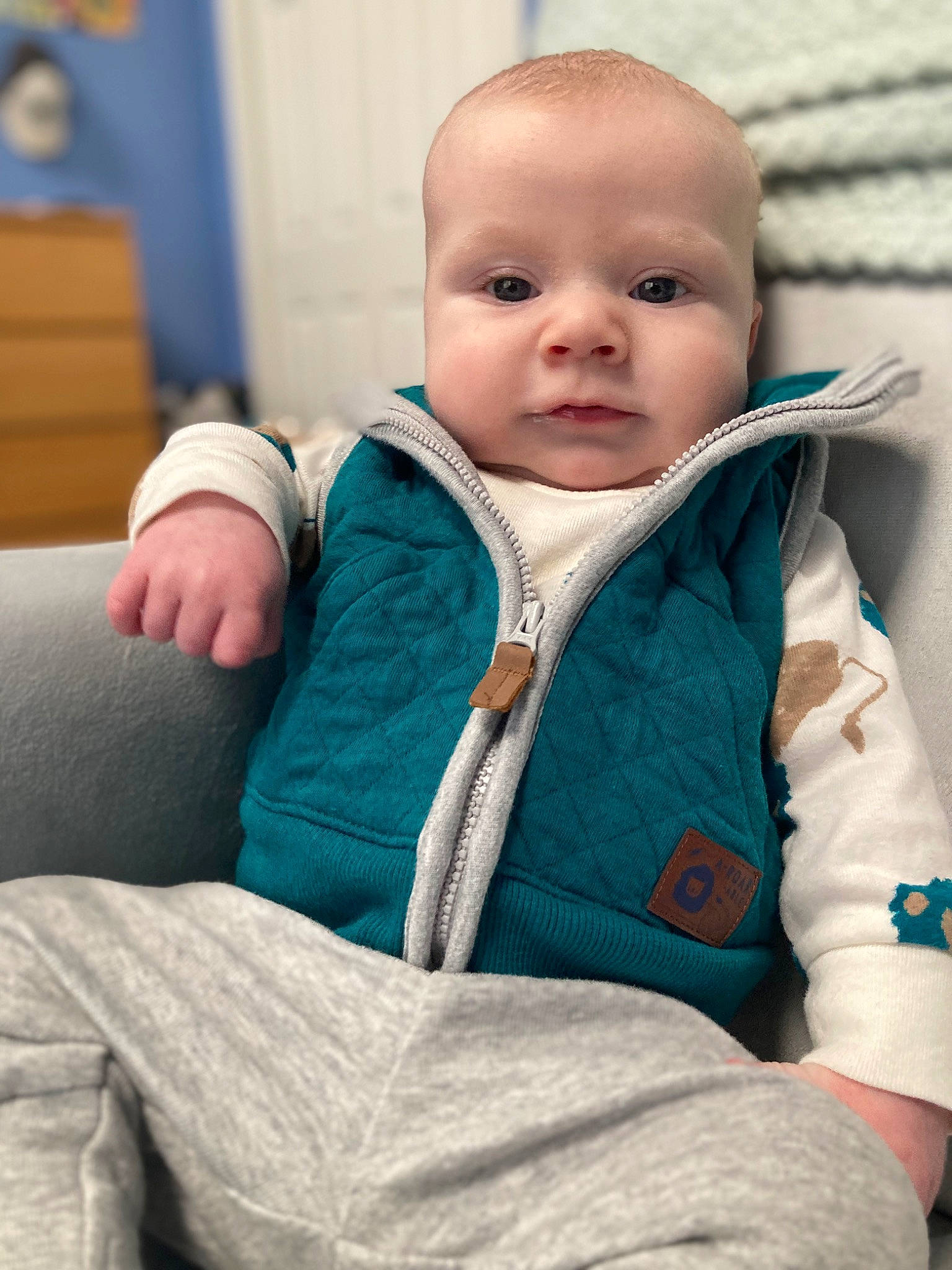 Timothy is registered to the contest to win money with this photo: baby, baby_products, baby_safety, baby_toddler_clothing, cheek, child, comfort, electric_blue, eye, eyebrow, happy, iris, linens, person, portrait_photography, room, sitting, skin, sleeve, toddler