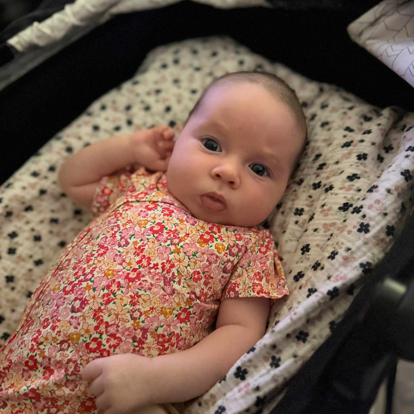 Bianca joined the competition — help win amazing prizes! baby, infant, child, portrait, floral_outfit, dress, bassinet, blanket, bedding, lying_down, indoors, face, eyes, wide_eyed, serious_expression, pacifier, patterned_fabric, close_up, photography, cozy