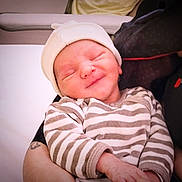 Adennis participe au concours pour gagner de l'argent avec cette photo : newborn, baby, infant, smiling, striped_clothing, hat, person, arms, holding, closeup, indoor, soft_light, cute, sleepy, portrait, child, human, newborn_baby, resting, tenderness
