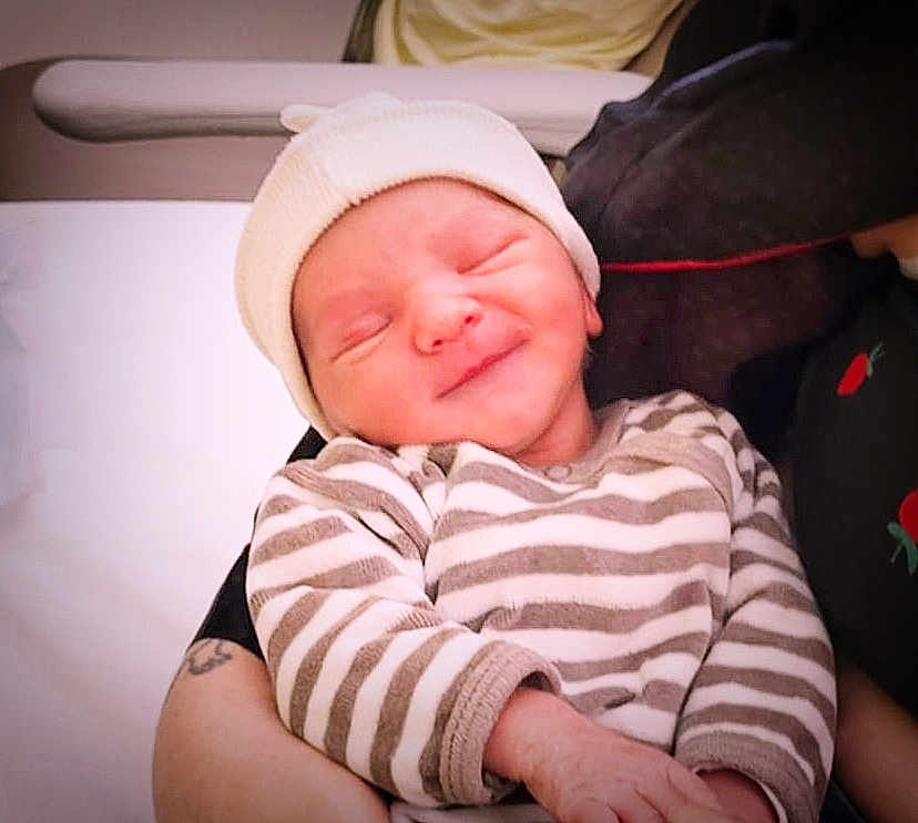 Adennis participe au concours pour gagner de l'argent avec cette photo : newborn, baby, infant, smiling, striped_clothing, hat, person, arms, holding, closeup, indoor, soft_light, cute, sleepy, portrait, child, human, newborn_baby, resting, tenderness