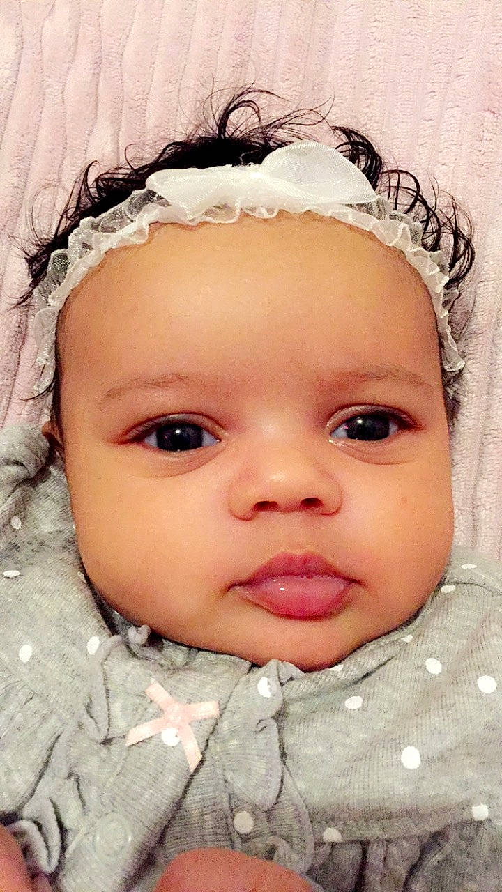 Jasmine is registered to the contest to win money with this photo: baby, cheek, child, chin, close_up, eye, eyebrow, face, forehead, hair_accessory, head, headgear, iris, lip, mouth, nose, person, pink, skin, smile