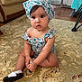 toddler, child, baby, indoor, carpet, headscarf, romper, sitting, curious, expression, floor, home, furniture, shoe, patterned, floral, cute, person, portrait, natural_light