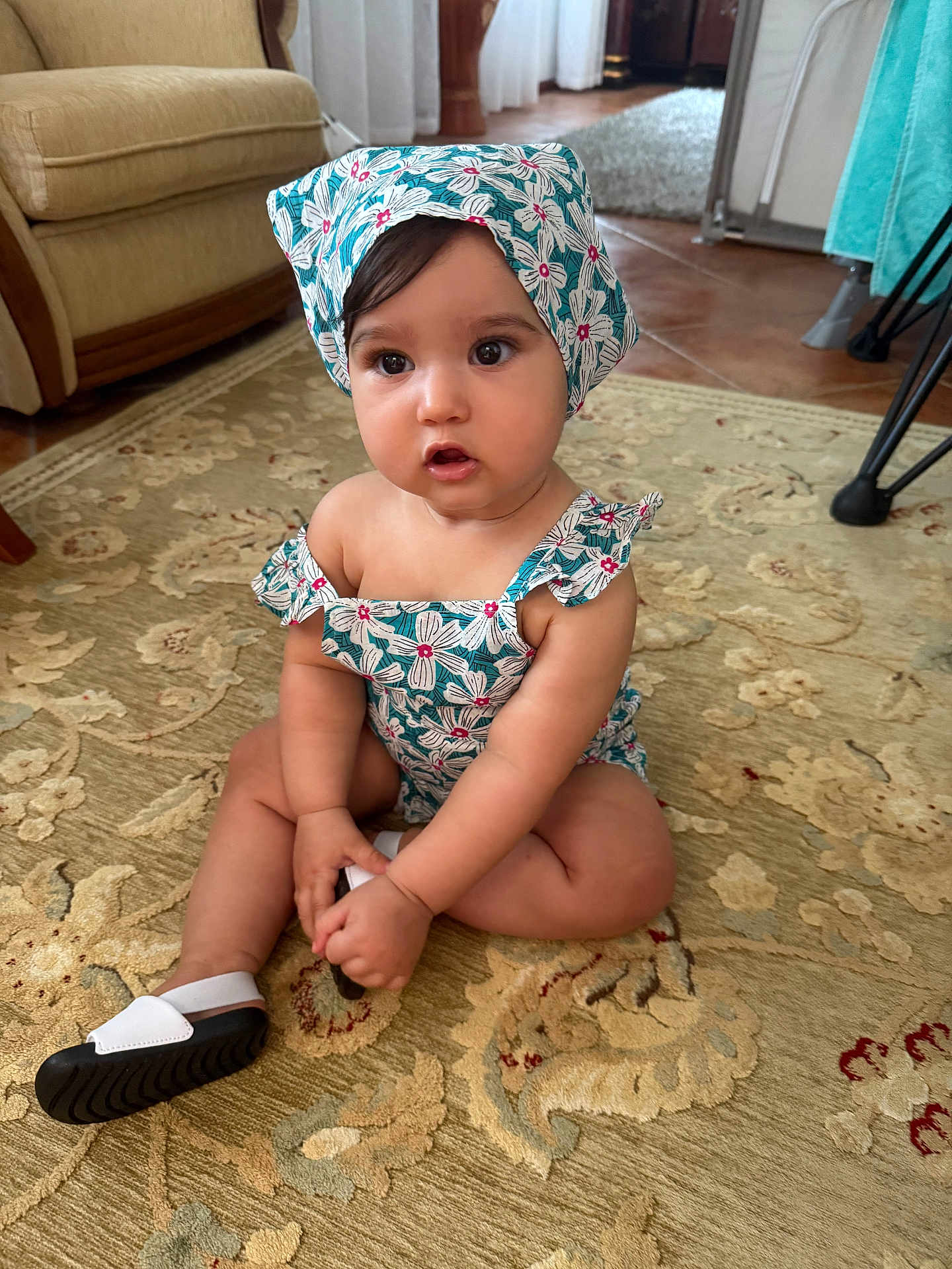 Alma participe au concours pour gagner de l'argent avec cette photo : toddler, child, baby, indoor, carpet, headscarf, romper, sitting, curious, expression, floor, home, furniture, shoe, patterned, floral, cute, person, portrait, natural_light