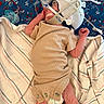 newborn, baby, infant, medical_device, breathing_tube, onesie, blanket, pacifier, hospital, lying_down, sleeping, headgear, swaddled, red_white_blue, texture, fabric, tiny, delicate, peaceful, care