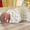 newborn, baby, swaddled, blanket, hospital, infant, sleeping, cap, medical_tube, nasal_tube, striped_sheet, bed, patient, healthcare, cute, peaceful, child, portrait, resting, indoors