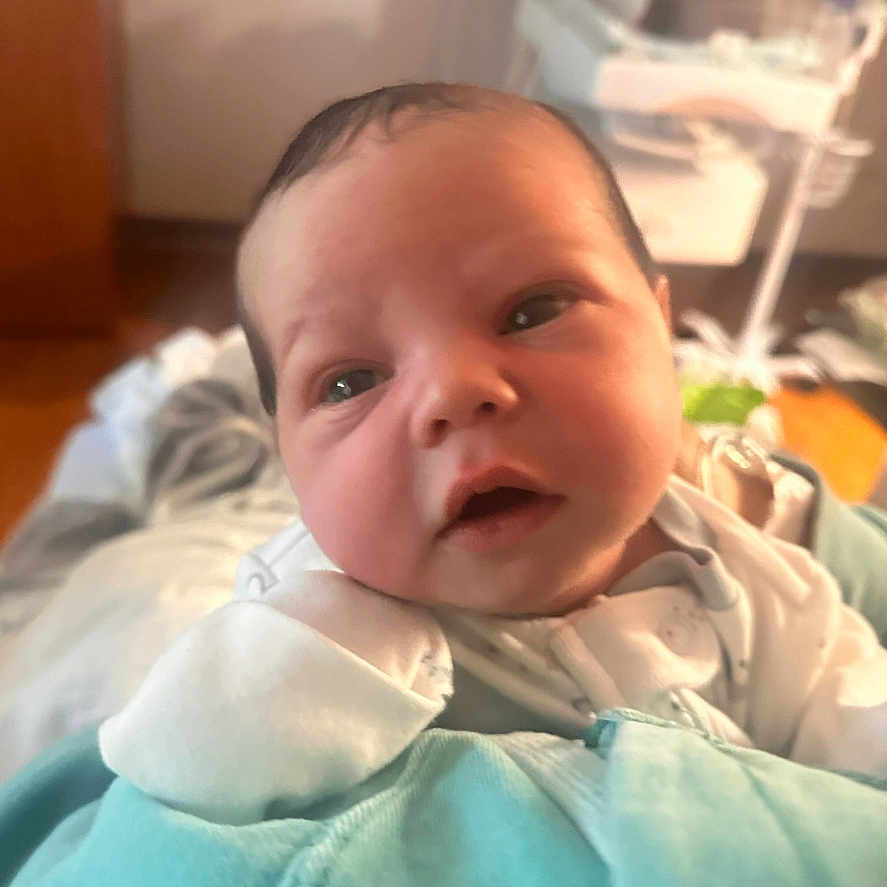 Theo is registered to the contest to win money with this photo: architecture, baby, bodypart, building, cushion, face, finger, frown, hand, happy, head, homedecor, hospital, indoors, newborn, person, photography, portrait, sad, smile