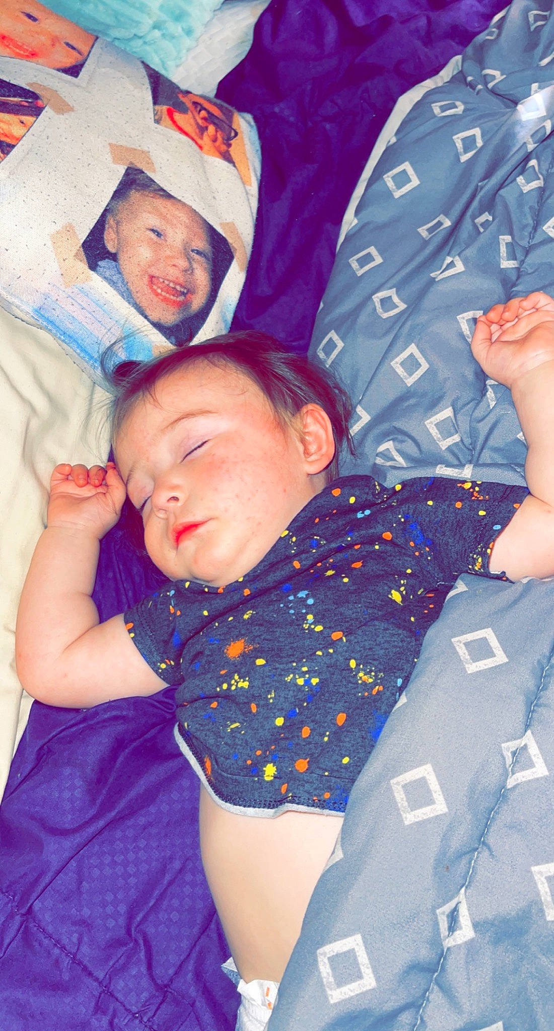 Kaycee is registered to the contest to win money with this photo: azure, baby, baby_toddler_clothing, child, comfort, cool, face, facial_expression, finger, gesture, happy, human, mouth, organ, person, product, purple, skin, sleeve, textile