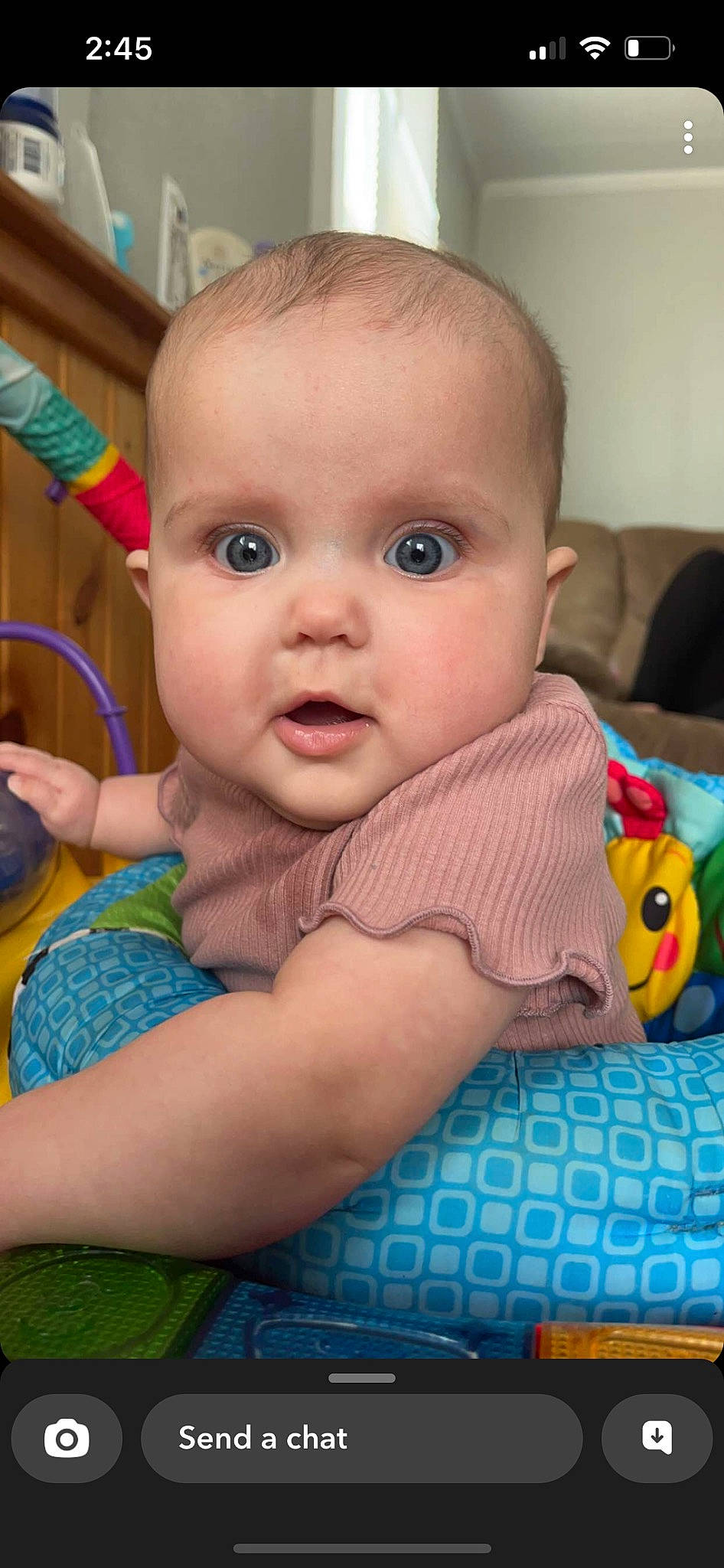 Cora joined the competition — help win amazing prizes! baby, baby_products, baby_toddler_clothing, blue, cheek, child, chin, eyelash, finger, flooring, happy, human_body, iris, mouth, nose, person, sitting, skin, smile, toddler