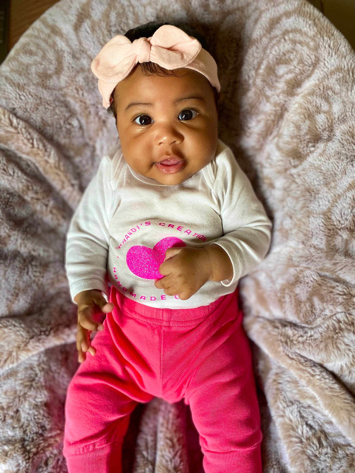 Aniyrah Scott is registered to the contest to win money with this photo: baby, infant, child, pink_bow, headband, white_shirt, pink_pants, blanket, soft_texture, cute, smiling, portrait, indoors, cozy, happy, small_hands, lying_down, closeup, face, adorable