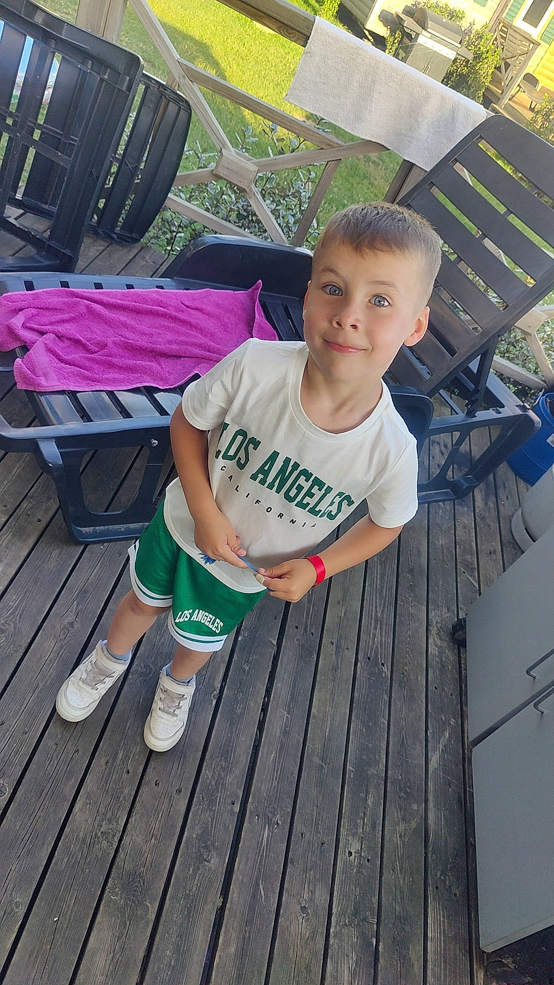 Elyano participe au concours pour gagner de l'argent avec cette photo : barefoot, chair, child, cool, deck, foot, fun, grass, happy, hardwood, human_leg, joy, leisure, outdoor_furniture, outdoor_table, person, sitting, t_shirt, thigh, toddler