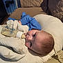 Elijah is registered to the contest to win money with this photo: baby, bottle, milk, blue_pajamas, blanket, cushion, sofa, quilted, indoor, feeding, infant, face, head, sleepwear, comfort, resting, child, person, soft_lighting, cozy
