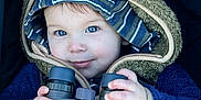 Carson is registered to the contest to win money with this photo: baby, binoculars, blue_eyes, child, close_up, cozy, curious, cute, exploration, face, hands, hooded_jacket, outdoor_gear, portrait, smile, striped_hat, toddler, warm, winter_clothing, young_child