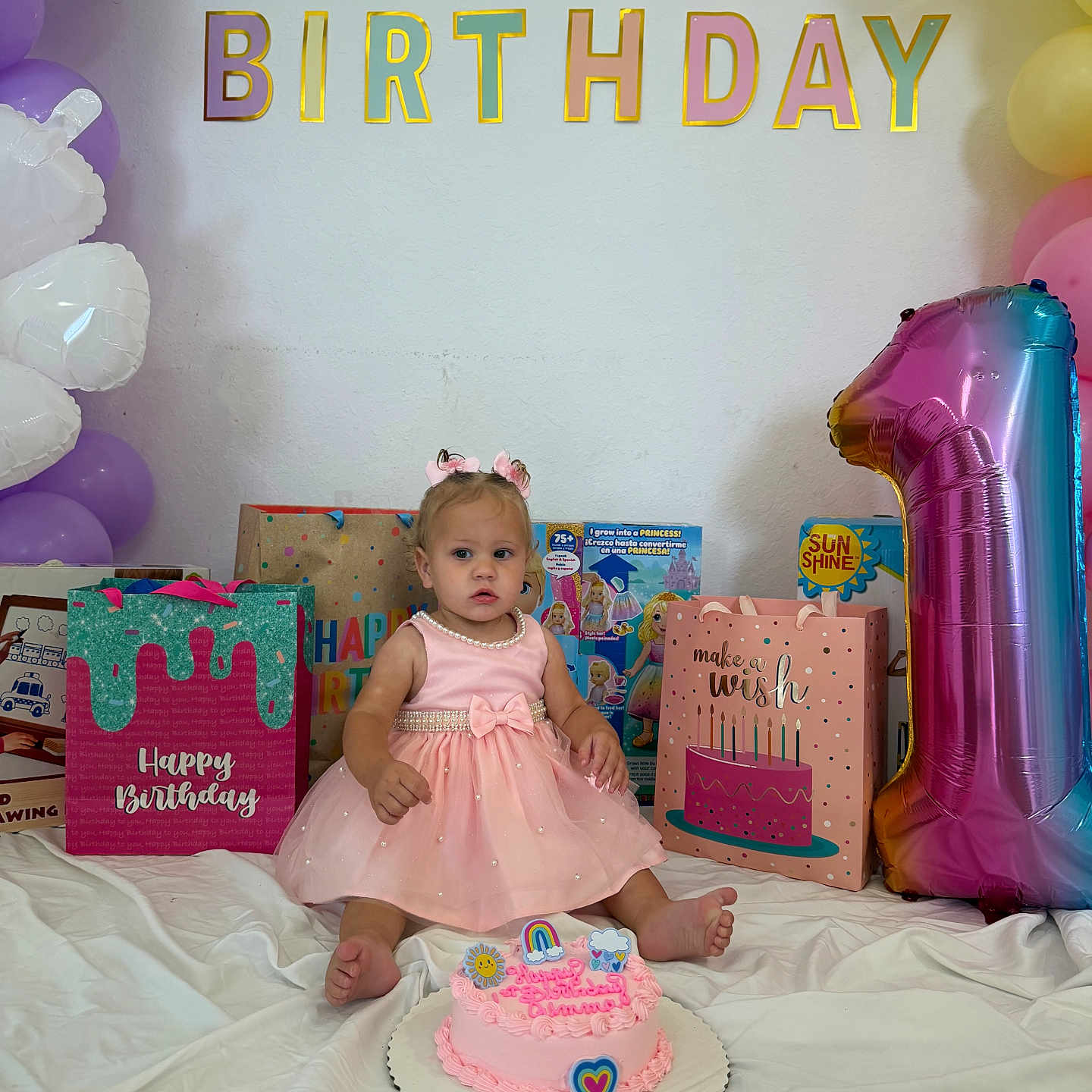 Gemma S Martinez is registered to the contest to win money with this photo: toddler, birthday, cake, balloons, gift_bags, pink_dress, number_one_balloon, party, celebration, child, birthday_cake, decorations, happy_birthday_sign, indoor, smile, girl, sitting, party_hat, present, white_sheet