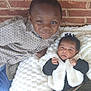 Leilani is registered to the contest to win money with this photo: child, baby, siblings, smiling, blanket, brick_wall, shirt, vest, cute, indoors, portrait, happy, face, clothing, black_hair, infant, boy, family, candid, toddler