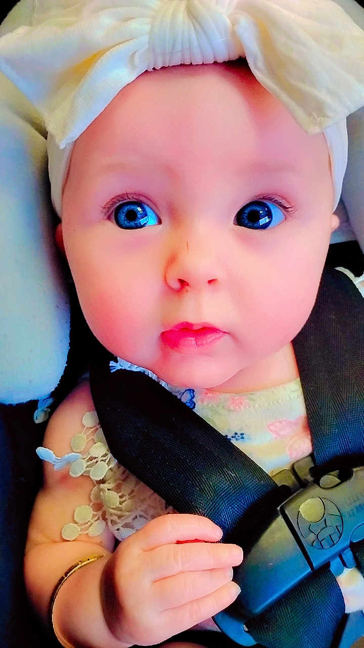 Baylee joined the competition — help win amazing prizes! baby, blue_eyes, headband, bow, car_seat, seatbelt, hand, infant, child, cute, portrait, closeup, clothing, bracelet, sitting, young, face, skin, expression, child_safety