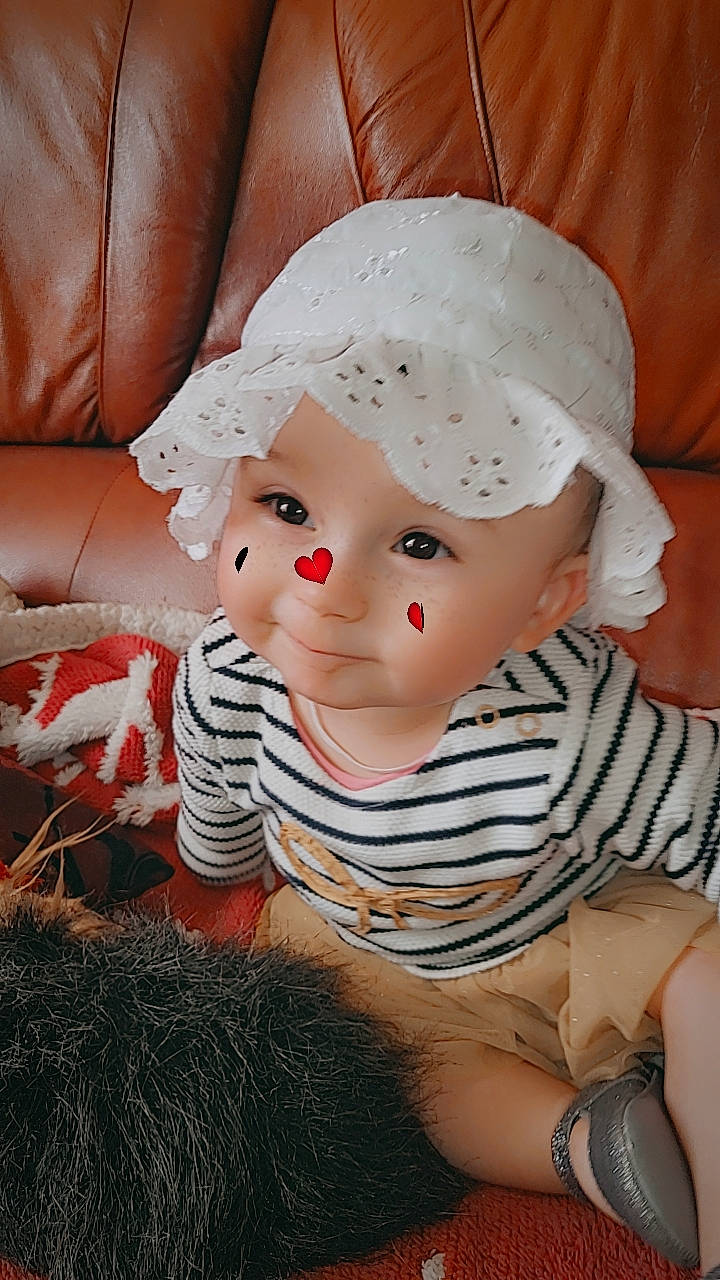 Sya participe au concours pour gagner de l'argent avec cette photo : baby, baby_toddler_clothing, beanie, cap, cheek, child, christmas, comfort, costume_hat, fashion_accessory, fur, hat, head, headgear, headwear, lip, pattern, person, portrait_photography, sitting