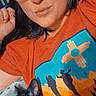 Zip is registered to the contest to win money with this photo: person, glasses, cat, black_cat, lying_down, tshirt, graphic_tee, indoors, sleeping_cat, closeup, portrait, cozy, resting, hand, eyewear, casual, relaxed, bed, hair, face