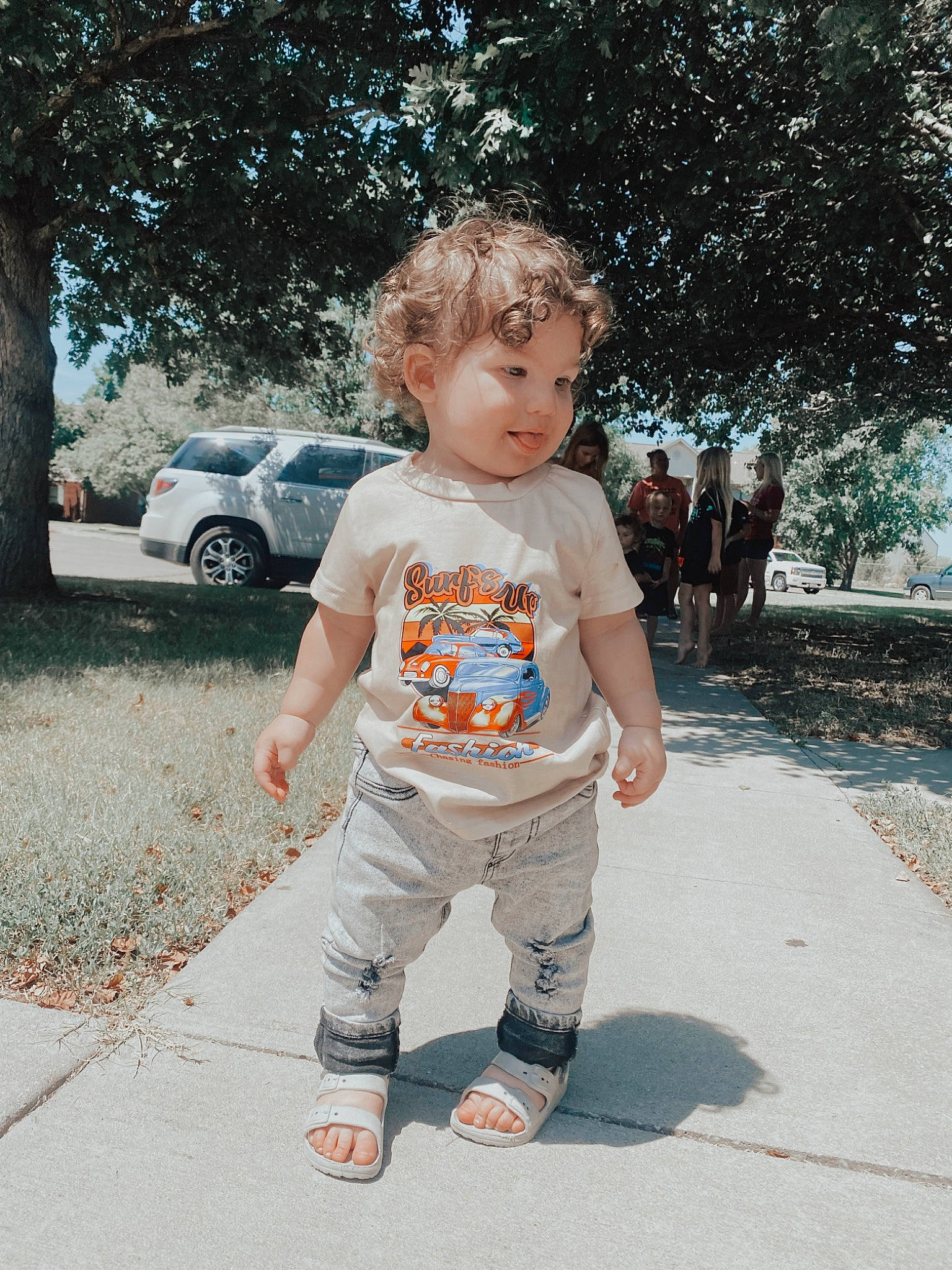 Holden is registered to the contest to win money with this photo: baby, baby_toddler_clothing, car, child, denim, family_car, fun, grass, happy, leisure, people_in_nature, person, plant, sleeve, t_shirt, tints_and_shades, tire, toddler, tree, under_exposed